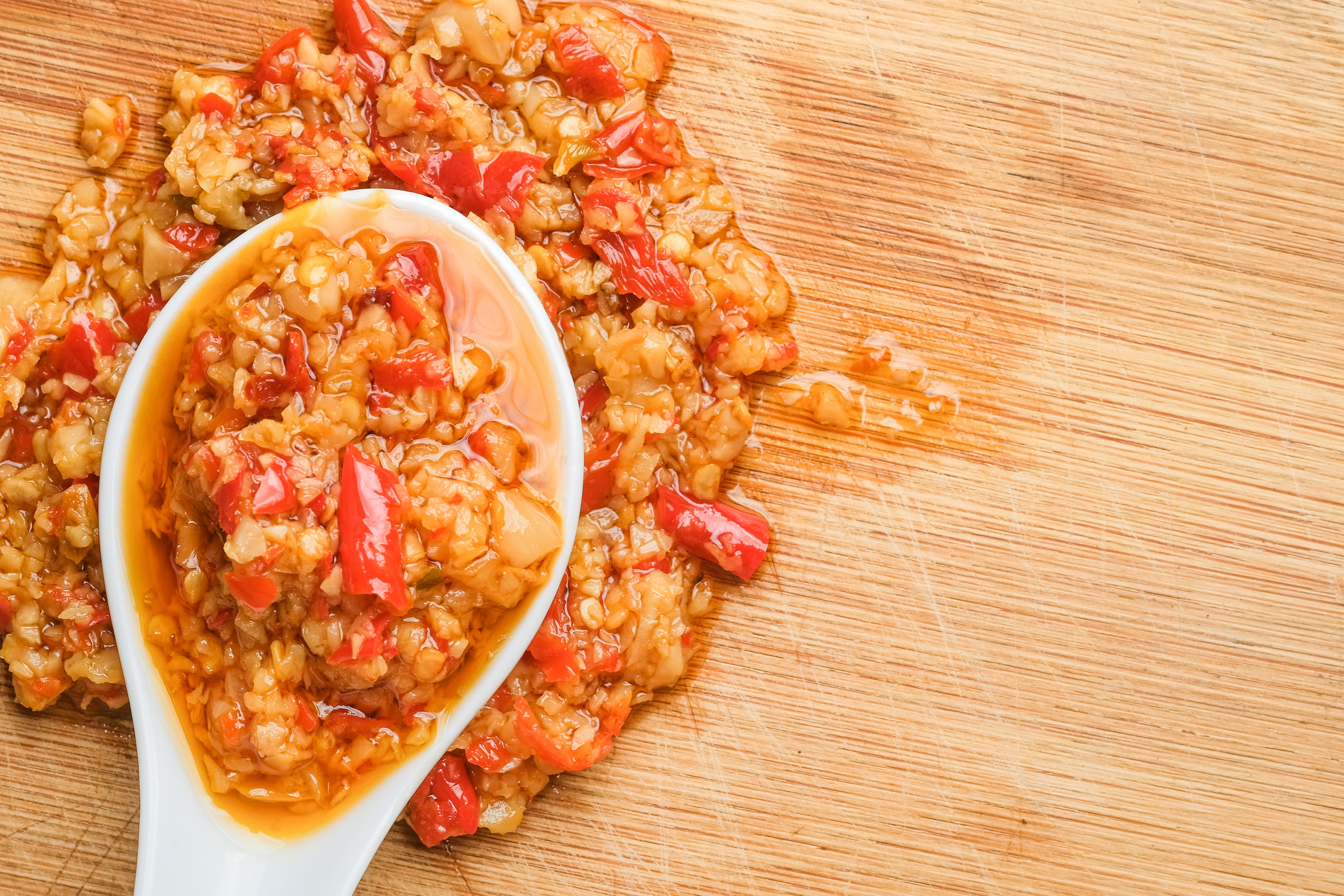 Spoon of Chili Garlic Oil on Wooden Background